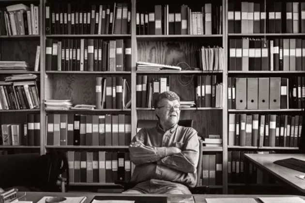 Carsten Peterson sitter i ett bibliotek. Bild. 